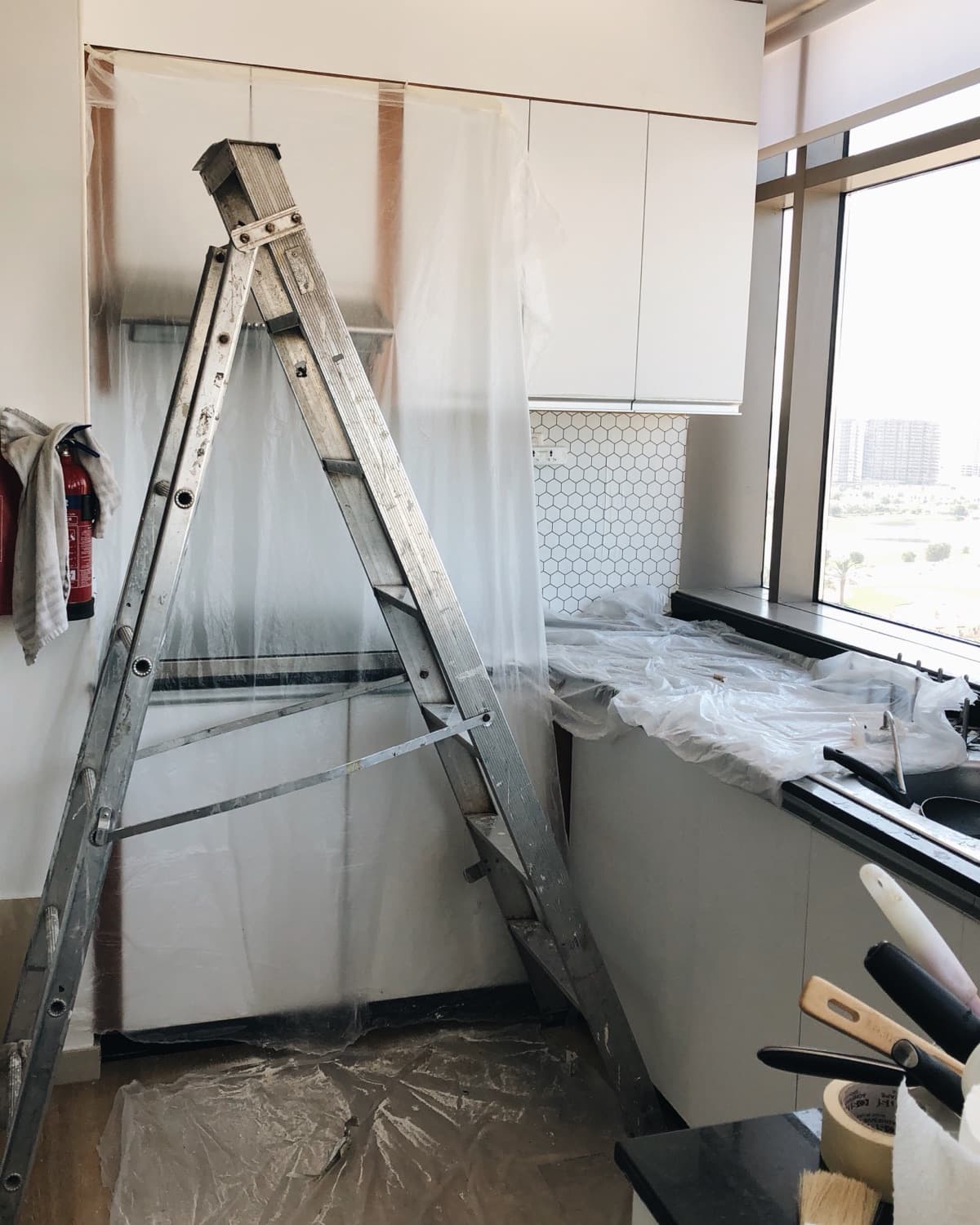 Kitchen renovation project with ladder and paintin.