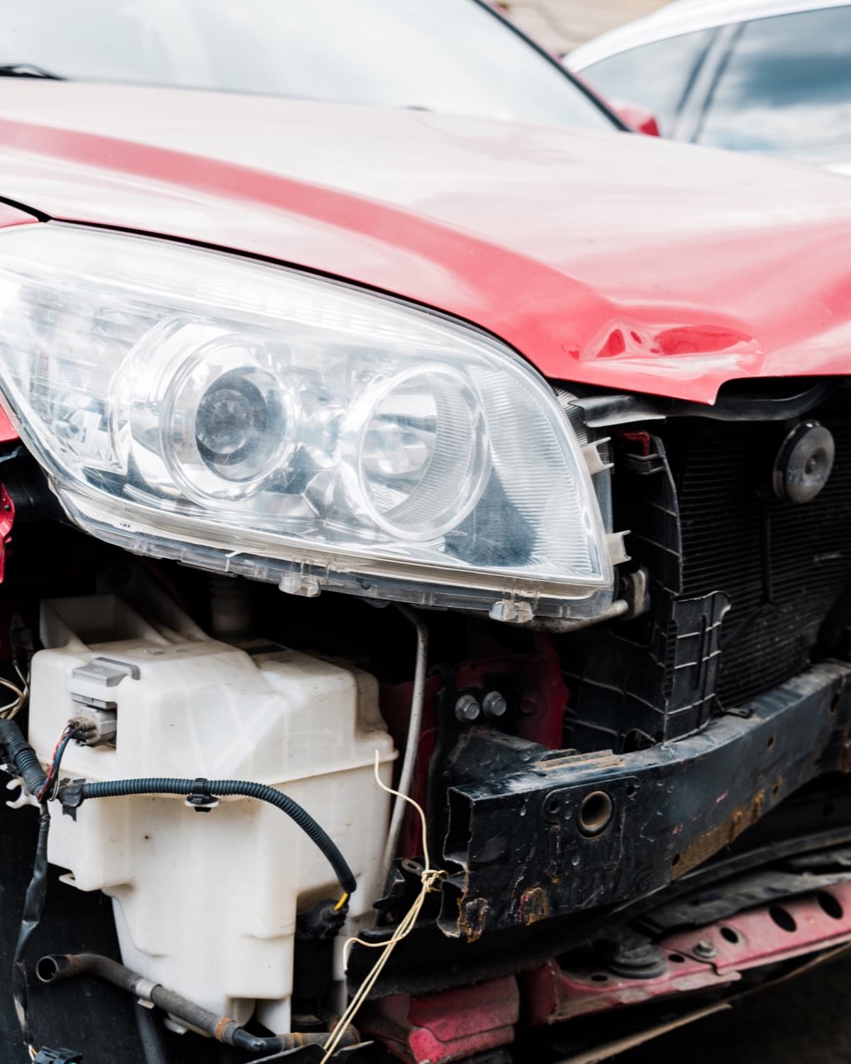 Damaged red car after accident on city street.