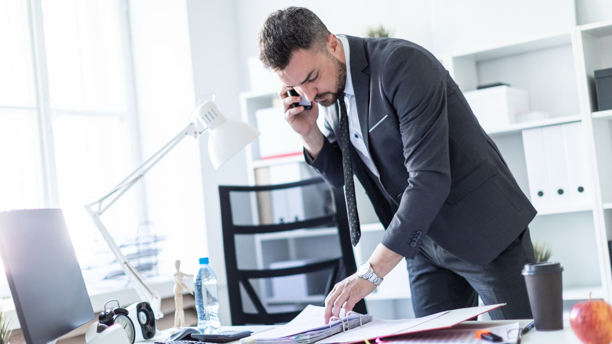 A man is standing near a table in the office talk.