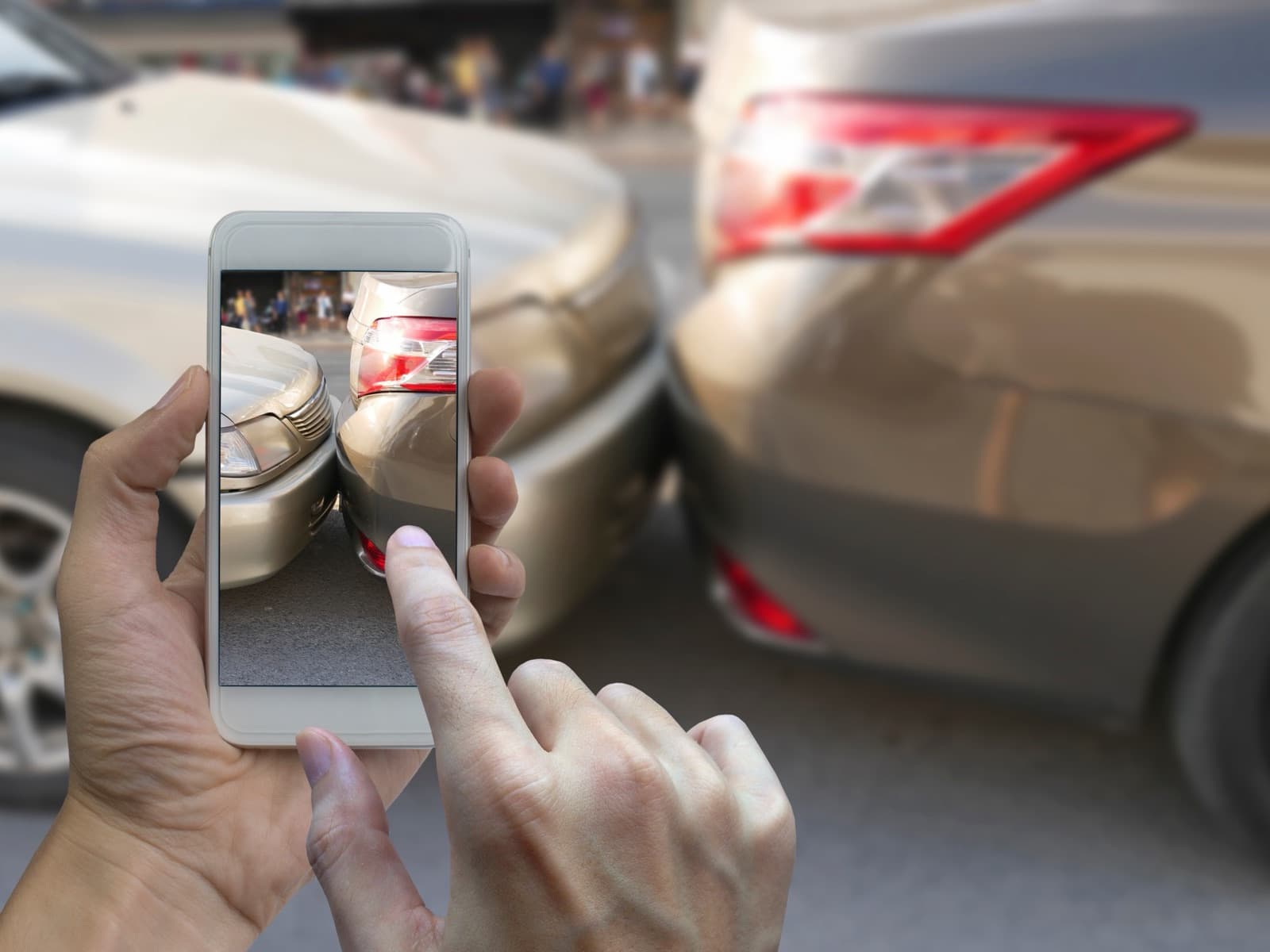 Taking photo of car accident on city street.